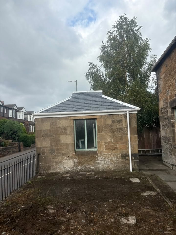 Finished slate roof and white roofline on the same stone property