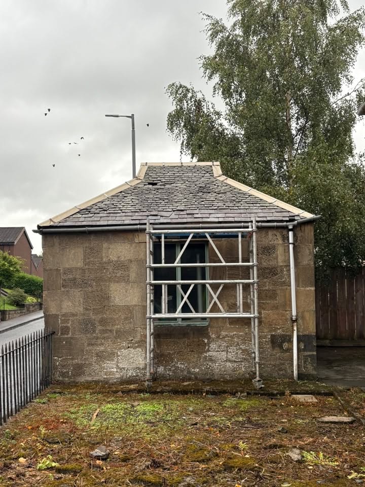 Worn slate roof on a stone property before roofing work